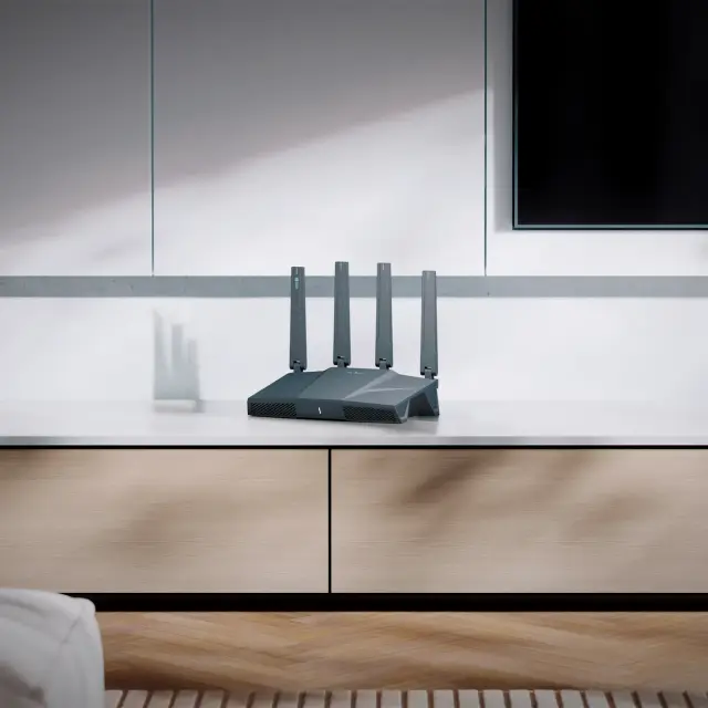 GL.iNet Flint 3e GL-BE6500 in a living room on a media console
